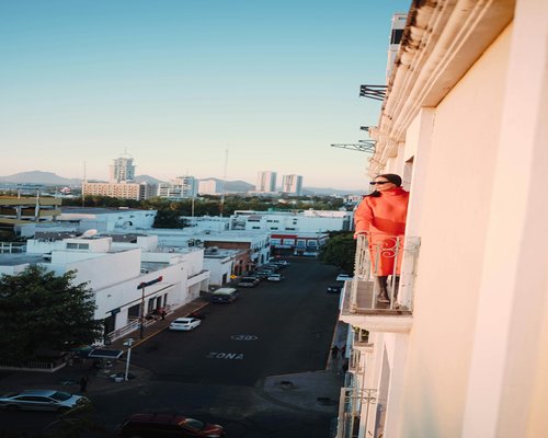 An individual finding balance while working from a balcony in a metropolitan city